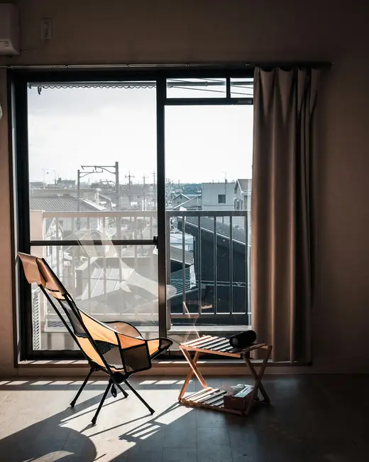 Sunlight streams into a simple room with chairs.