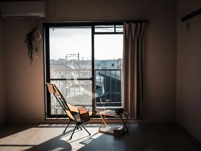 Sunlight streams into a simple room with chairs.
