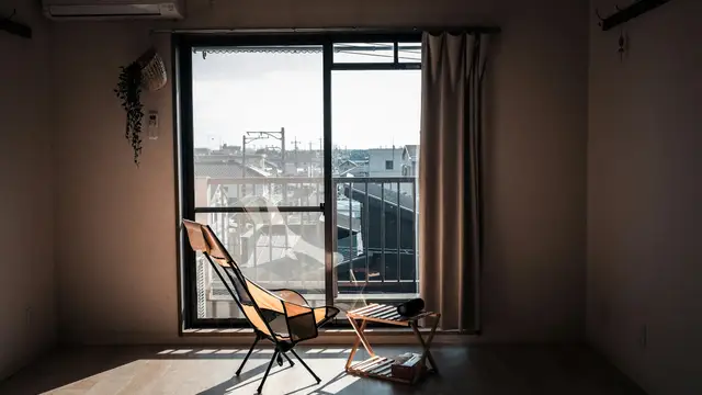 Sunlight streams into a simple room with chairs.