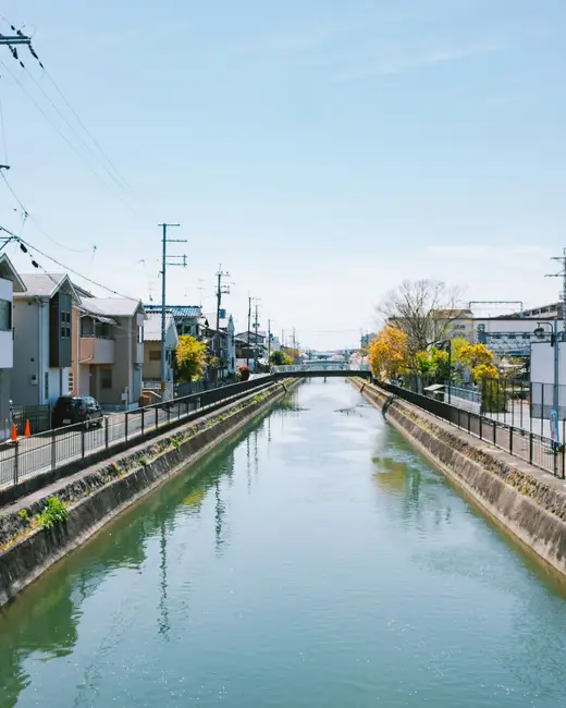 Canal running through a residential area with train tracks.