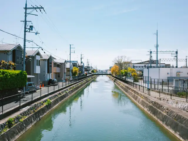 Canal running through a residential area with train tracks.