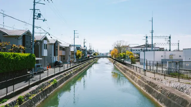 Canal running through a residential area with train tracks.