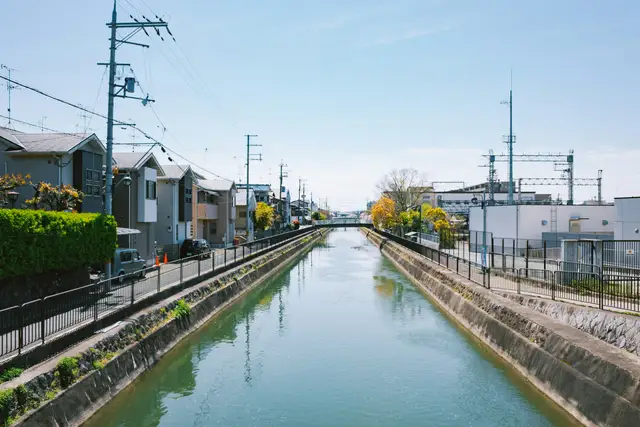 Canal running through a residential area with train tracks.