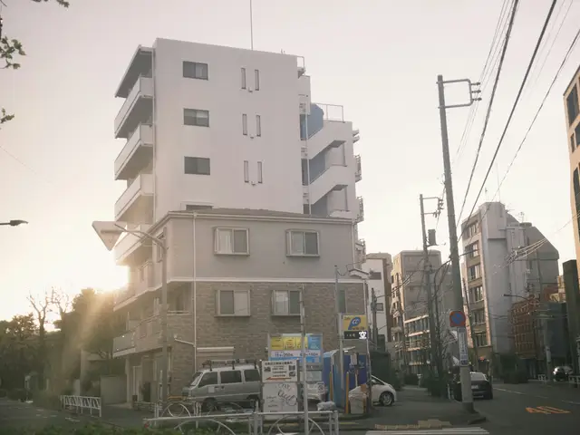 Apartment buildings on a street at sunset.