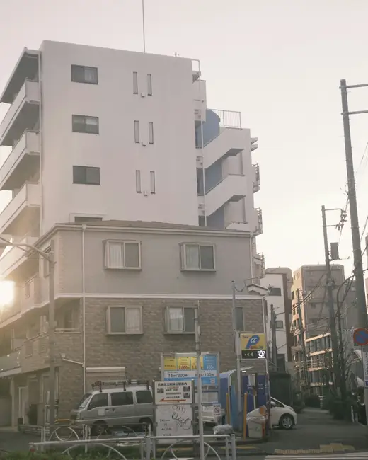 Apartment buildings on a street at sunset.