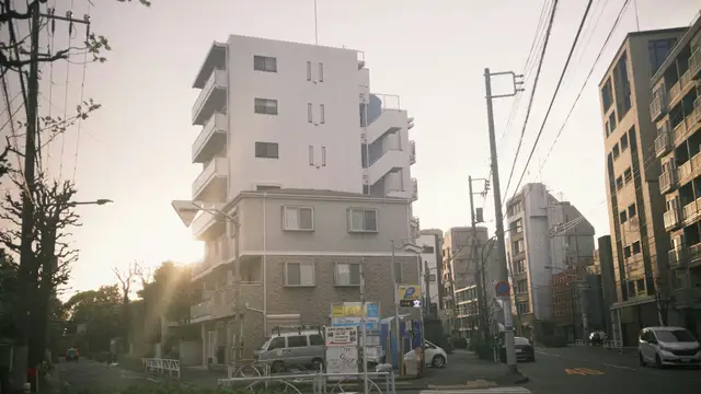 Apartment buildings on a street at sunset.